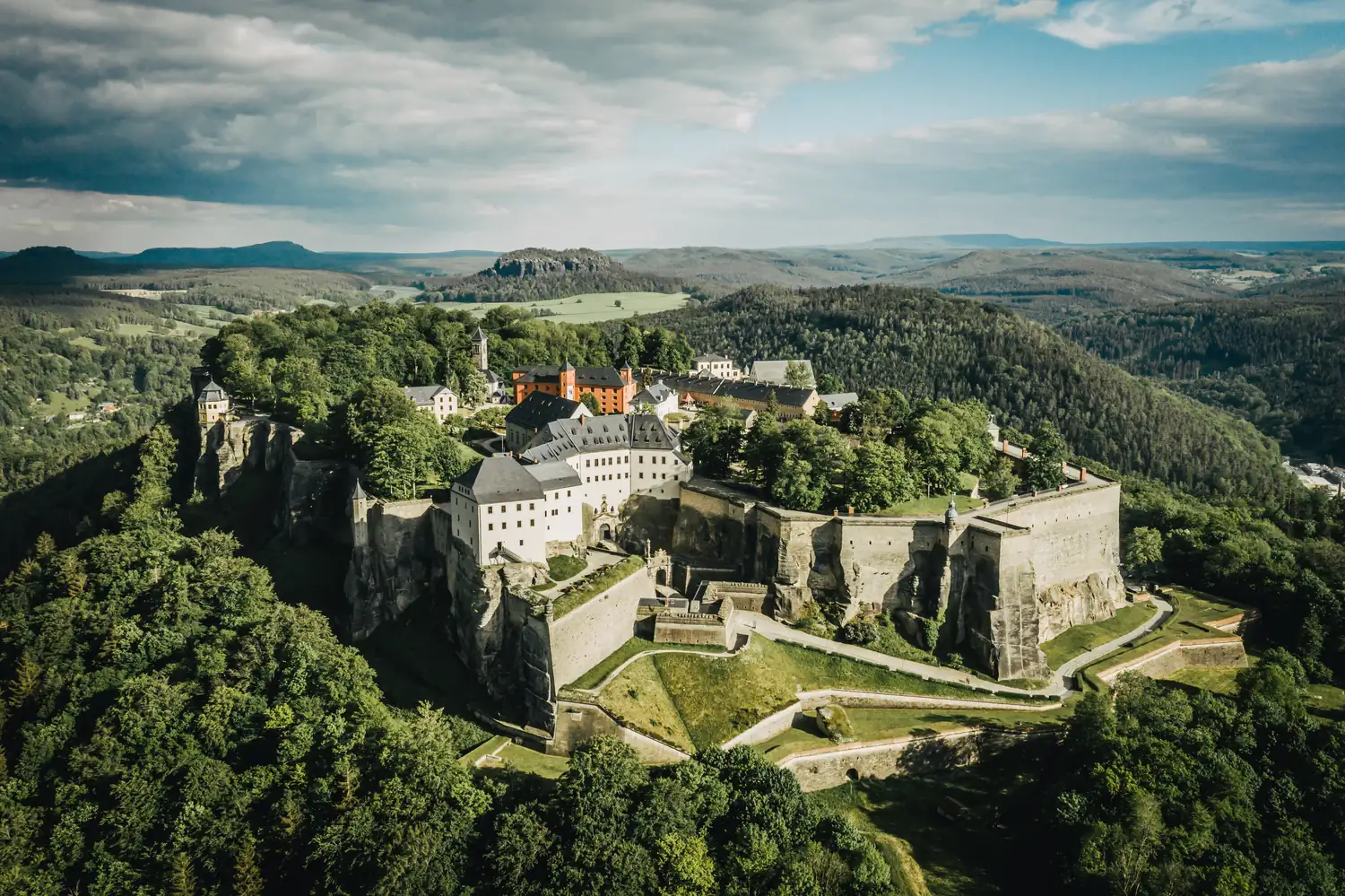 Luftaufnahme einer Festung auf einem bewaldeten Berg