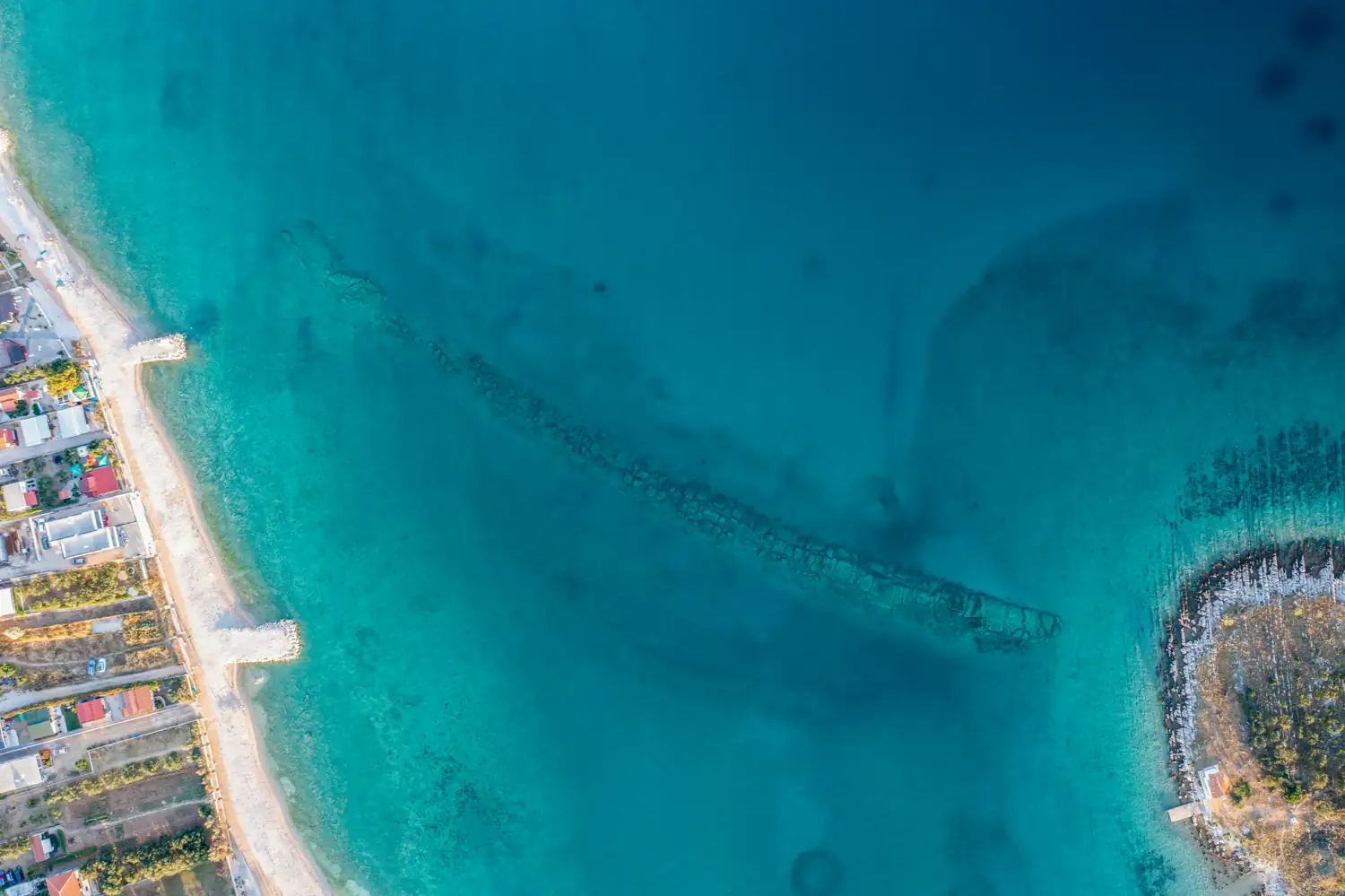 Luftaufnahme einer Küste mit Strand und türkisfarbenem Wasser