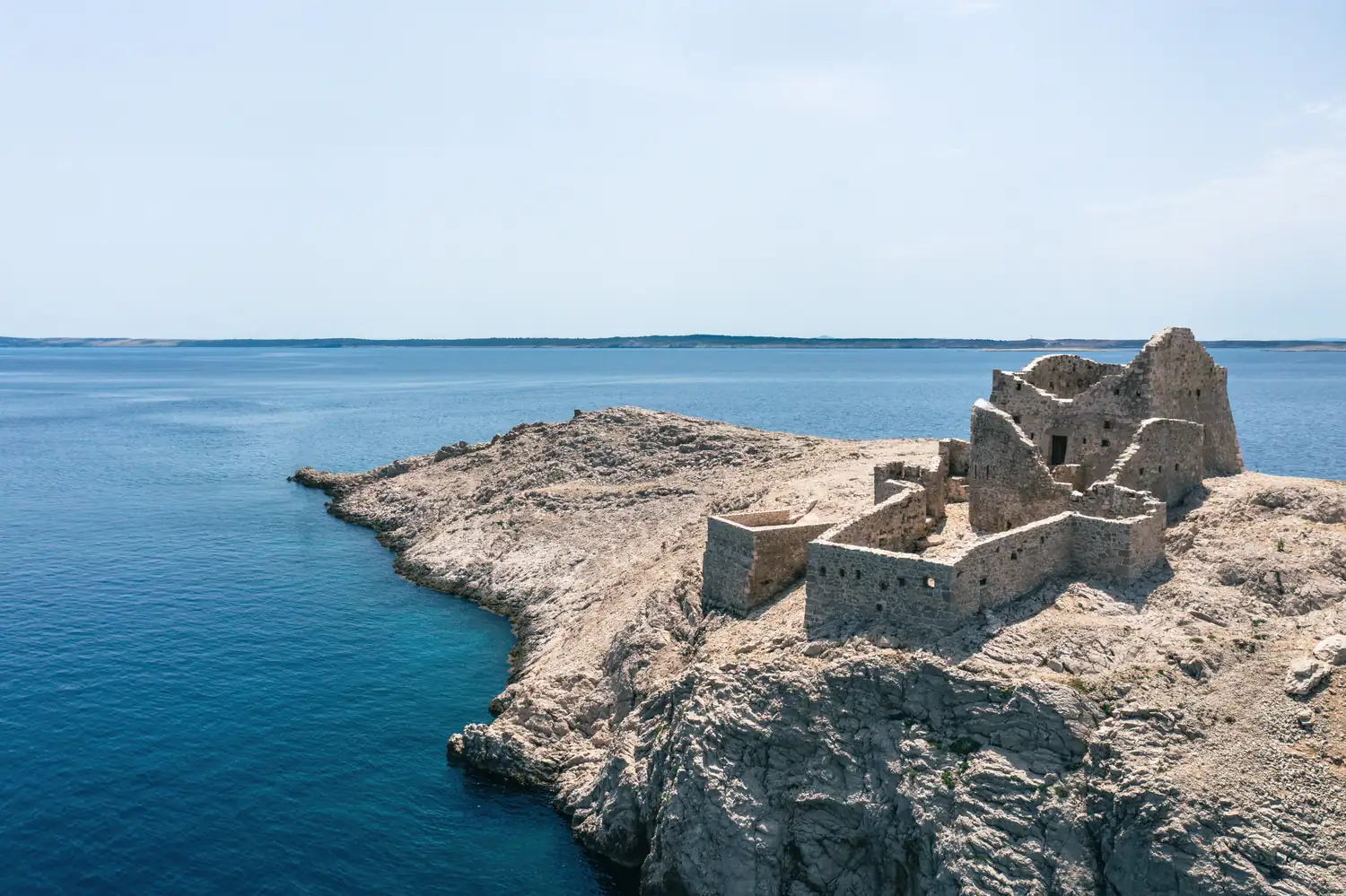 Ruine auf einer Felseninsel im Meer