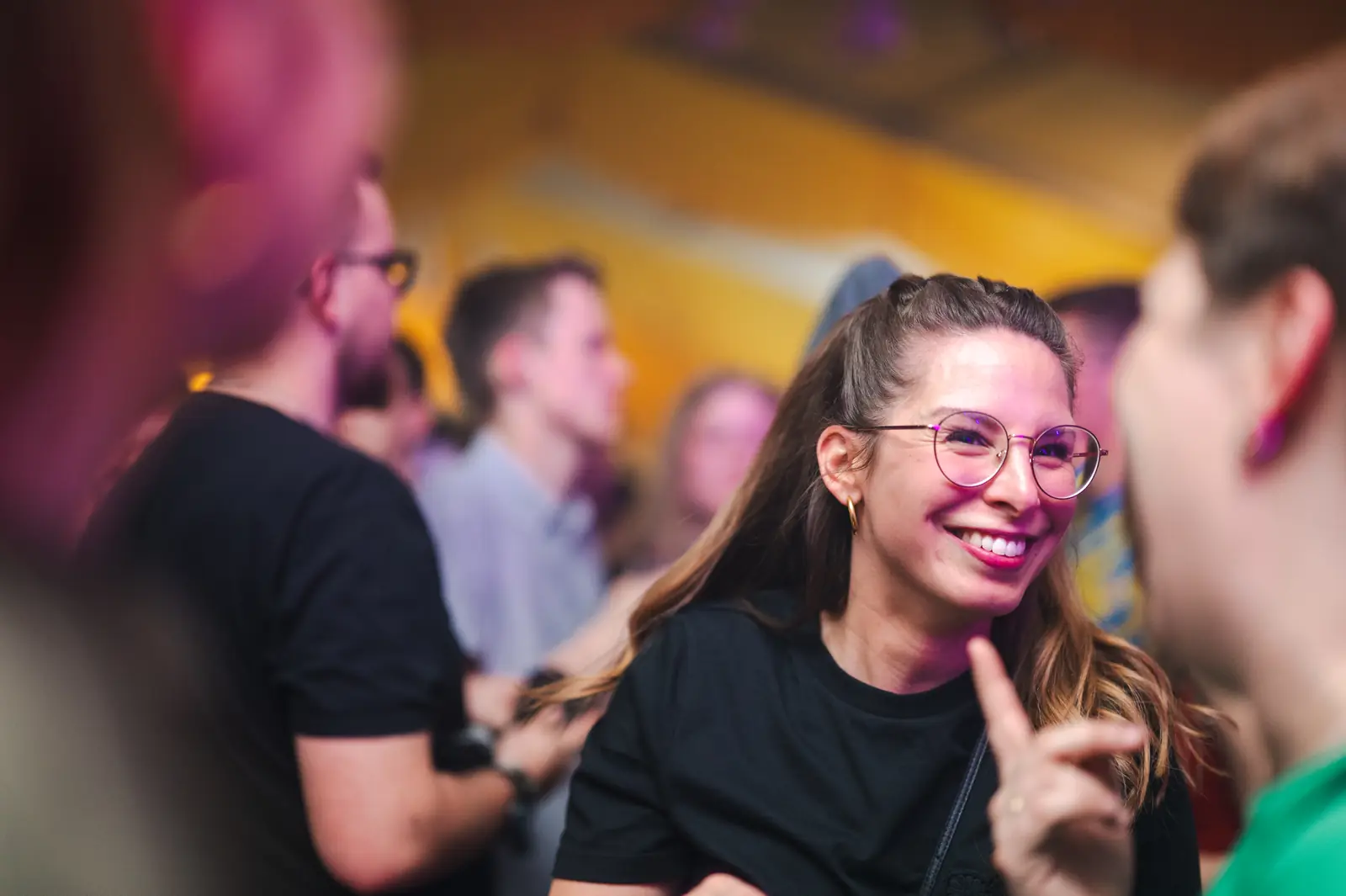 Lachende Frau mit Brille in der Menge