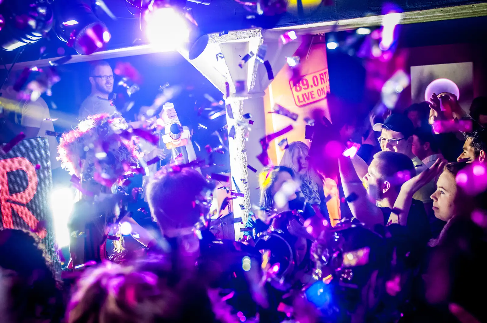 Club mit Menschenmenge und Konfetti vor der Bühne