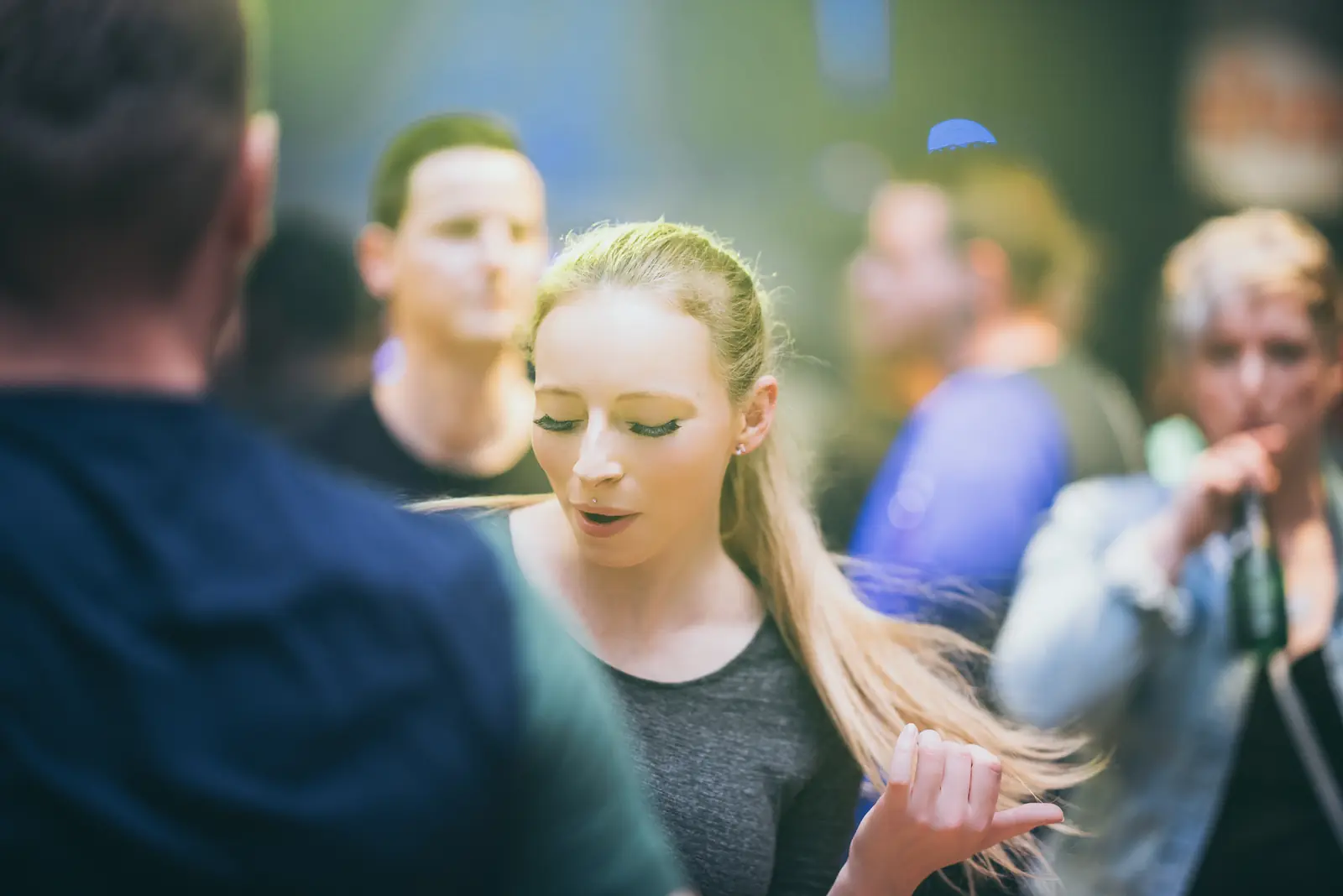 Blonde Frau tanzt zwischen anderen Gästen