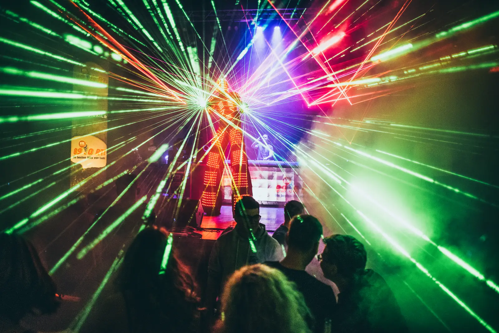 Laser-Show mit grünen und roten Strahlen über der Tanzfläche