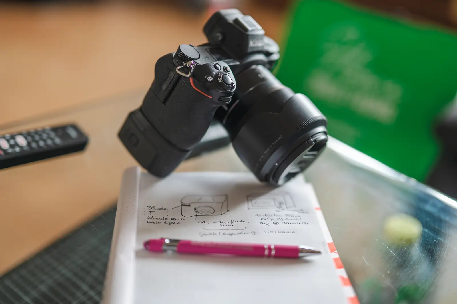 Kamera liegt auf einem Notizbuch mit Skizzen für eine Fototour