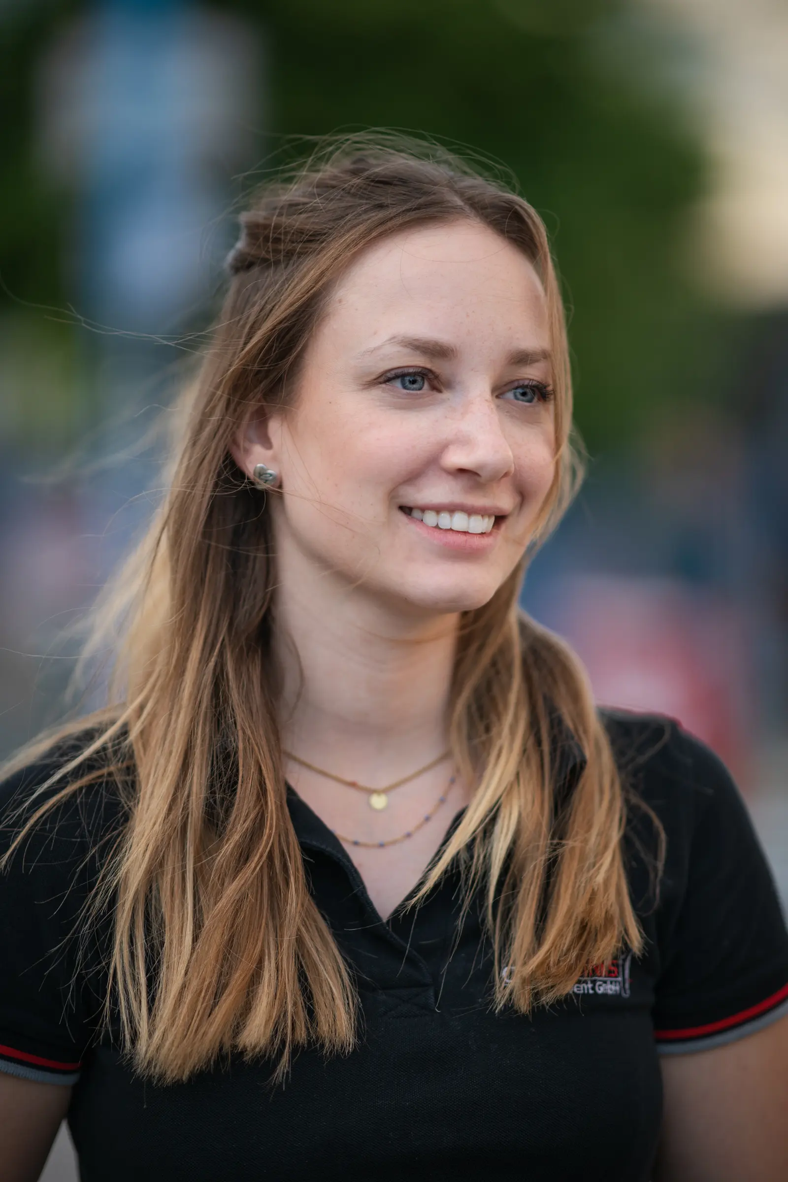 Lächelnde Frau im schwarzen Poloshirt