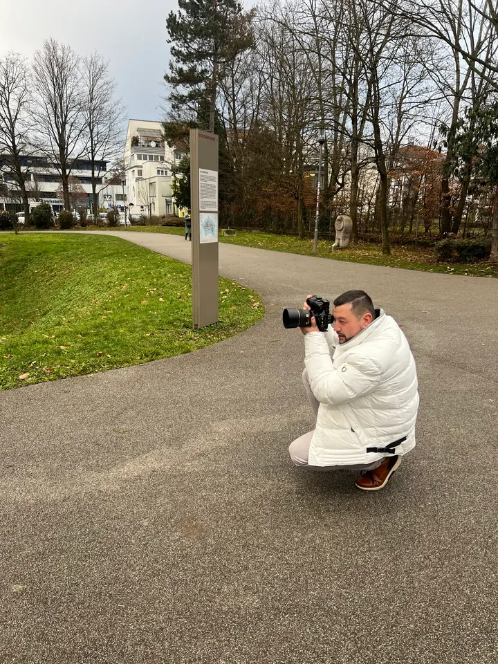Fotograf mit Kamera beim Fotografieren im Park